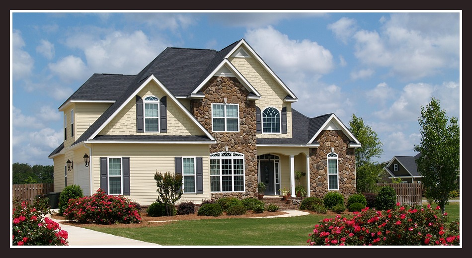 Two story residential home with both stone and board siding on the facade.